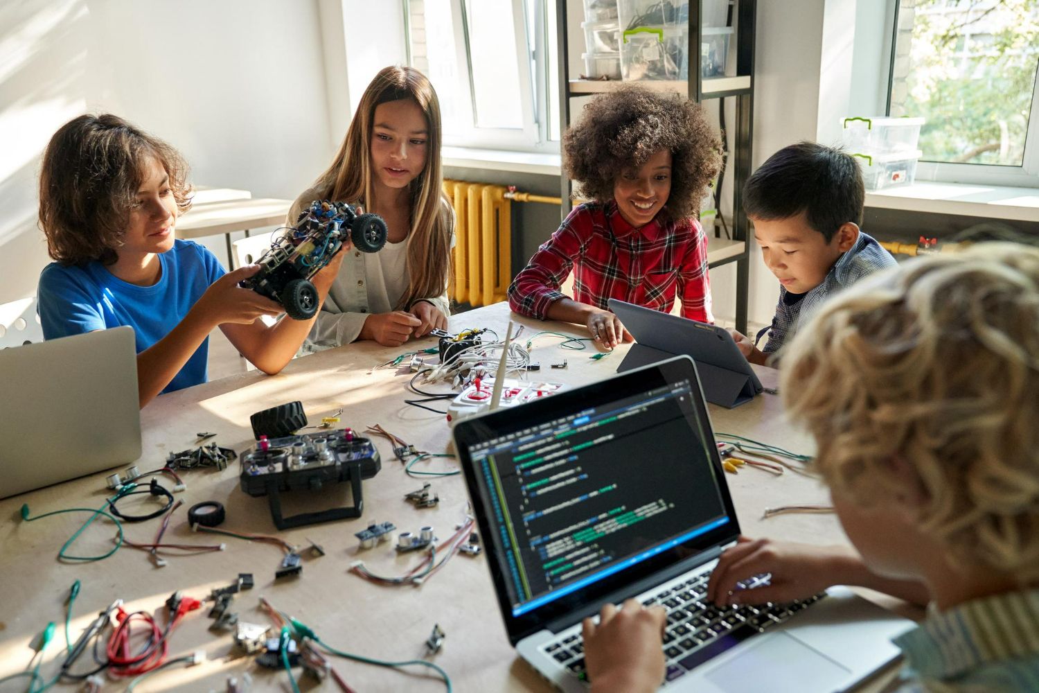 5 children at a STEM summer camp in Virginia working together to build and code a robotics project
