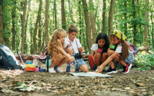 kids at summer camp working on a nature project together with a map puzzle