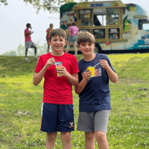 2 boys having a snack break outdoors at piedmont family ymca summer camp