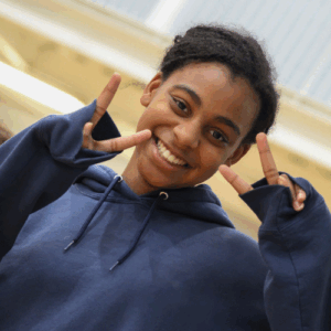 teen at camp at YMCA giving peace sign