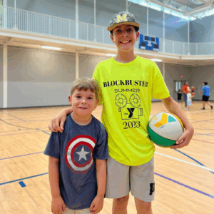 teen and young boy playing basketball as part of the Counselor - in -training program at the Piedmont YMCA