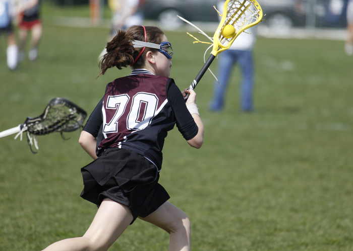 girl playing lacrosse at summer sports camp