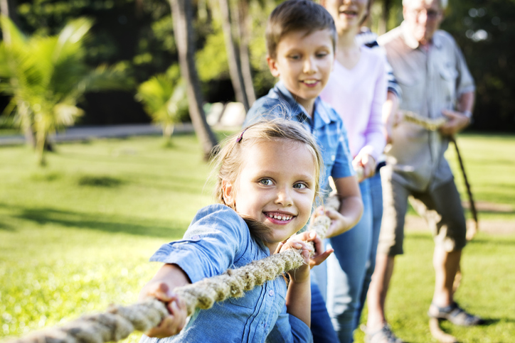 kids playing tug-o-war outdoors at summer camp games