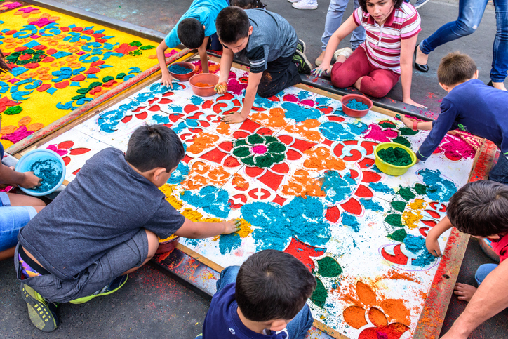 Children outdoors creating a colorful group mural project at summer camp