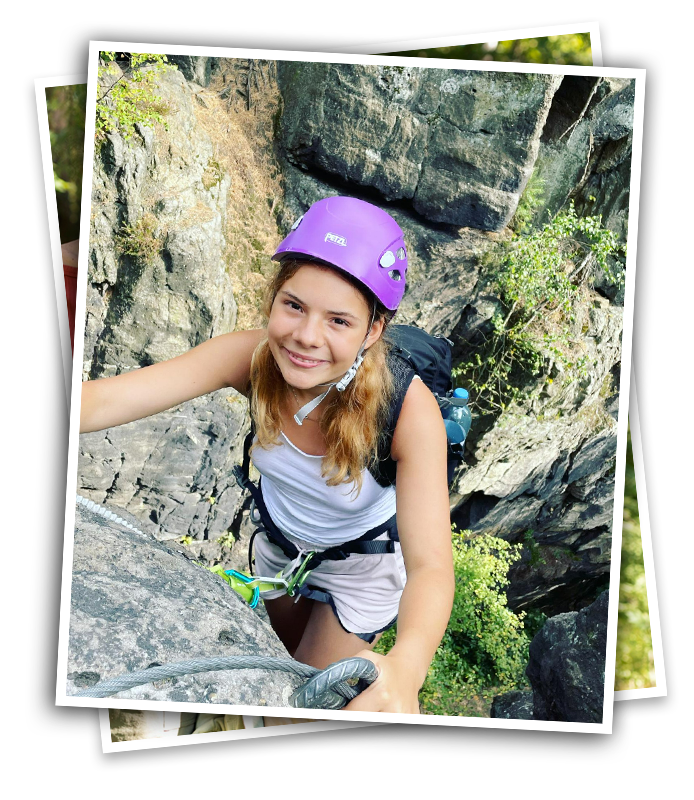 tween reaches the top of her rock climb at camp