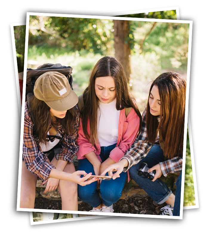 three teenagers at summer camp going birdiing