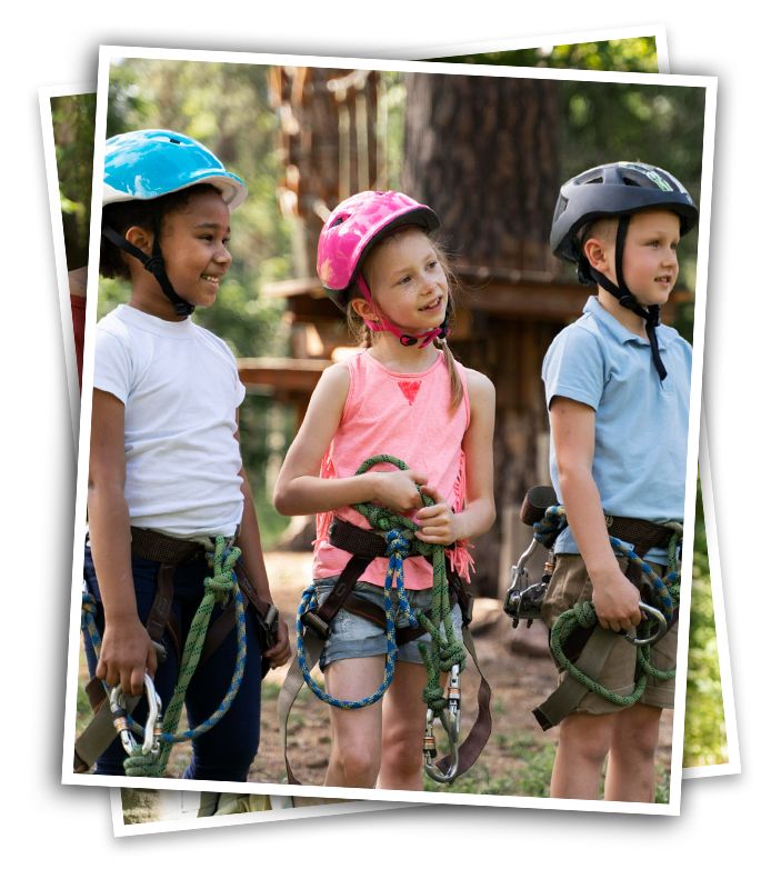 happy kids in safety harnesses and helmets at an adventure camp