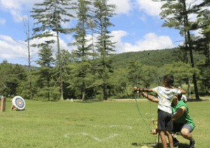 Young girl in archery activity shooting a bow